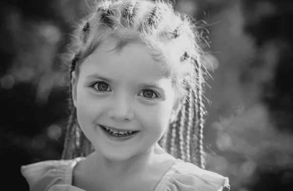 スタイリッシュなヘアロープのドレッドロックを持つ子供の女の子 ブラーの背景の屋外でファッショナブルなヘアスタイルの子供 子供の美しさとファッション — ストック写真