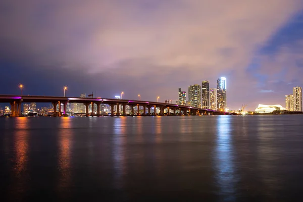 マイアミ市の高層ビル群のスカイラインパノラマと反射して海の上の橋 — ストック写真