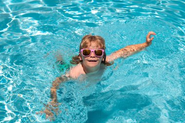 Yüzme havuzunda bir çocuk. Yaz etkinliği. Yaz tatili, havuzda yüzmek. Sağlıklı çocuk yaşam tarzı