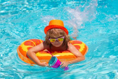 Komik çocuk suratı. Yüzme havuzunda su sıçratan çocuk. Aktif sağlıklı yaşam tarzı, çocukla yaz tatilinde yüzme sporu aktivitesi. Çocuk su oyuncakları