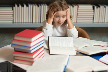 Okullu çocuk. Okula dönelim. Okul kütüphanesinde okuyan bir öğrenci. Kütüphanede kitap okuyan çocuk kitaplığı arkaplanı
