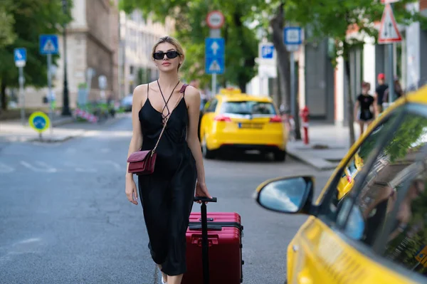 在欧洲度假 旅行者 时尚游客 穿着时尚服饰 提着手提箱的游客妇女 提着手提箱的女人坐出租车 女模特儿周末出国旅行 旅行概念 — 图库照片
