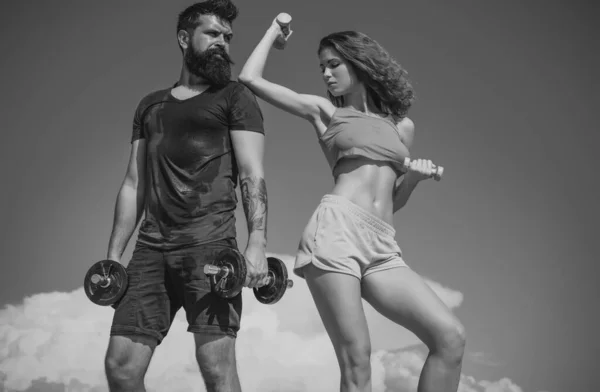 活泼的健身夫妇 留着胡子的男人和性感的女人在户外锻炼 活泼的夫妇带着哑铃训练 — 图库照片