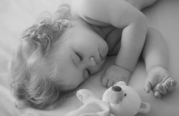 赤ちゃんはおもちゃで家のベッドで寝て 子供はベッドで寝ています 子供の赤ん坊はおもちゃで寝ている 子供たちは眠い顔 小さなお子様でも安心してお休みいただけます — ストック写真
