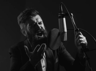 Şarkıcı bir müzik stüdyosunda şarkı söylüyor.