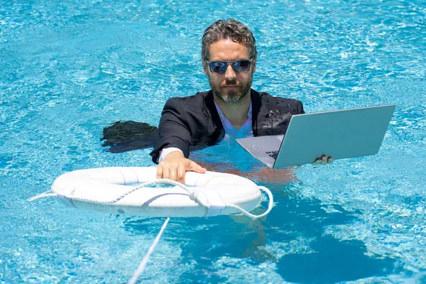 Support business. Business man in suit hold laptop and support lifebuoy in swim pool. Rescue support swimming ring in water for businessman. Helping and support business. Save and help business