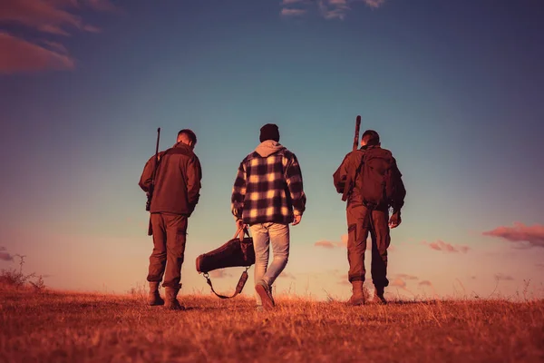 stock image Hunters after the hunt. Rifle Hunters Silhouetted in Beautiful Sunset. Closed and open hunting season. Hunting Licenses