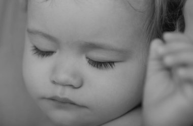Yatakta uyuyan tatlı bir bebeğin makro yüzü. Kapalı, uykulu çocuklar.