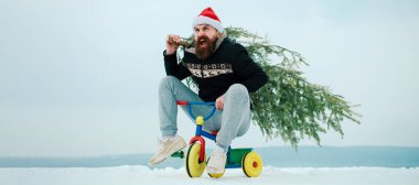 Bisikletli çılgın kış adamı Noel ağacını önemsiyor. Kışın arka planda kardan adam. Kış bayrağı için kardan adam