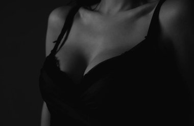 Lingerie concept. Sexy breas, boobs in bra, sensual tits. Beauty slim female body. Closeup of sexy girl boob in black bra