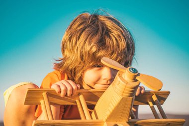 Çocuk rüya görüyor ve parkta oyuncak bir uçakla oynuyor. Seyahat hayalleri. Geliştirme, büyüme, hayaller ve planlar. Hayal gücü ve rüya kavramı. Çocuklarla yaz tatili