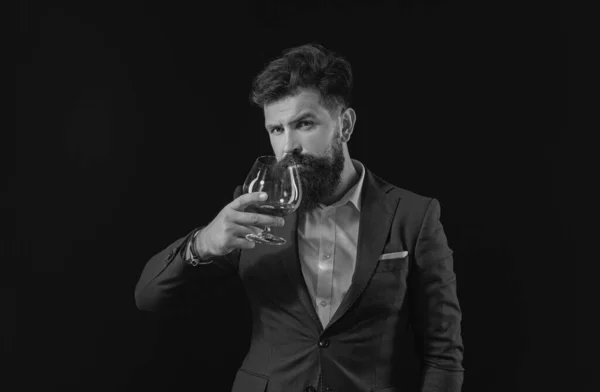 アルコールの概念 贅沢な飲料の概念 髭を生やしたバーテンダーがグラスブランデーを持っている ファッションスタイルのコンセプト ガラスから酒を飲む男 — ストック写真