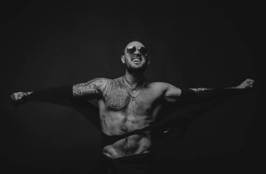 Öfkeli adam siyaha izole edilmiş. İnsan gücü. Kaslı üstsüz erkek model. Atletik genç adam gömleğini yırttı ve mükemmel çıplak vücudunu gösterdi.