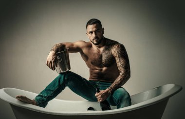 Seksi vahşi çıplak adam banyoda küvete oturur, erkekler şampanya ile tatil yapar. Noel 'i ya da doğum gününü kutlamak için. Özel seks partisi