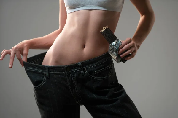 瘦长的腰围瘦女人穿超大号牛仔裤体重减轻的概念饮食 巧克力节食 — 图库照片
