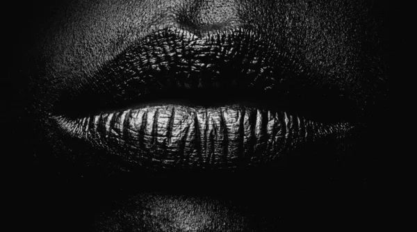 Golden lips closeup. Gold metal lip. Beautiful makeup. Golden lip gloss on beauty female mouth, closeup