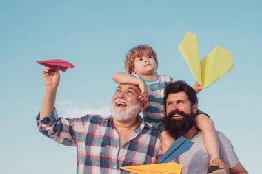 Baba ve oğul dışarıda eğleniyor. Baba ve oğul. Baba ve oğul mavi gökyüzünde oynuyorlar. Uçak uçmaya hazır. Baba oğul ve büyükbaba birlikte dinleniyorlar.