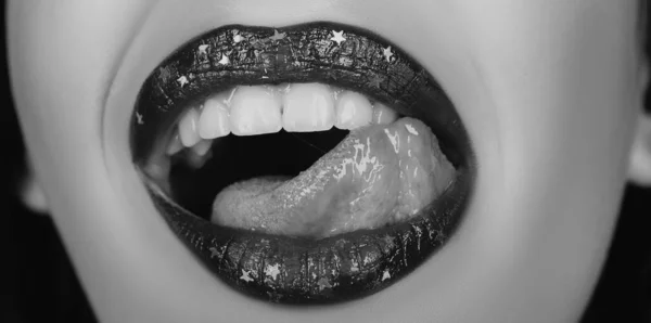 女人性感的妆容 嘴唇上的牙齿被黑色背景隔离 而艺术则用紫色阴影把嘴涂成金属色 — 图库照片