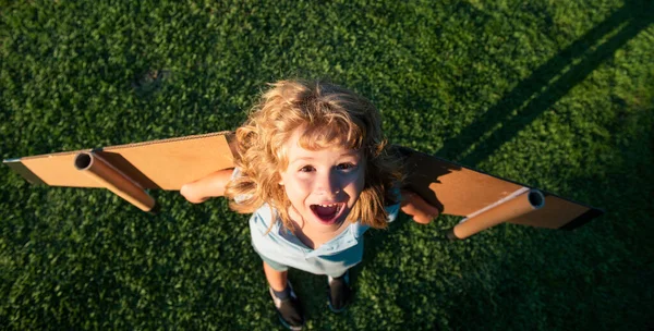 おもちゃのジェットパックで遊んでいる子供を笑っています 子供のパイロット宇宙飛行士や宇宙飛行士の夢 ボールボードの翼を持つ飛行士の少年 — ストック写真