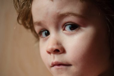 Şaşırmış küçük bir çocuğun portresi. Çocuk kavramı yakın planda. Kafa vuruşu çocuk portresi