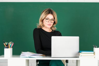 Tahtadaki oldukça genç bir lise ya da üniversite öğretmeni. Okuldaki genç beyaz kadın profesör, tahtanın altyapısı hakkında derse başlamaya hazır.