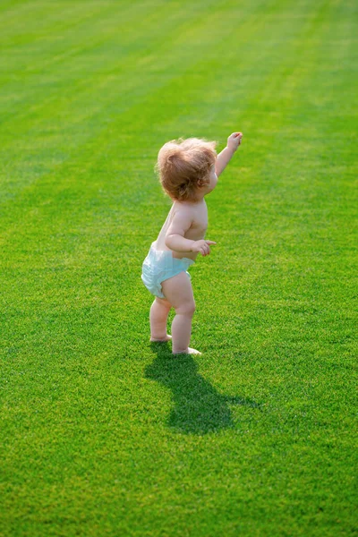 美しい春の緑のフィールドで赤ちゃん オムツパンツで公園で暖かい春の時間 — ストック写真