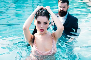 Celebrity couple, fashionable pair of elegant people. Romantic couple on Party in swimming pool. Concept of relations fashion beauty and love clipart