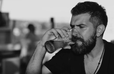 Sakallı ve bıyıklı hippi iş gününden sonra bira içer. El yapımı bira. Bir bardak birası olan kendine güvenen bir adam. Bira barı ve bar.