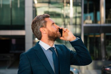 Akıllı telefon kullanan bir iş adamı. İş adamı telefonda konuşuyor.