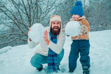 Happy father and son play on winter Christmas time. Happy smiling family on sunny winter day. Concept of friendly family clipart
