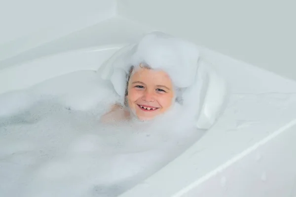 快乐地笑着 头上带着泡沫 在厨房的洗澡池里泡着很多泡沫 — 图库照片
