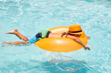 Summer rahatla. Çocuk havuzda oynuyor. Yaz tatili kavramı. Yaz çocukları plajdaki deniz suyunda yüzen yüzükle portre yaparlar.