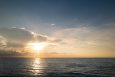 Gün batımı deniz manzarası. Gökyüzünde gün batımı ve renkli bulutlar. Sakin dalgalarla renkli sahil gündoğumu. Doğa deniz göğü. Mavi gökyüzüne ve denize karşı farklı renkte bulutlarla gün doğumu