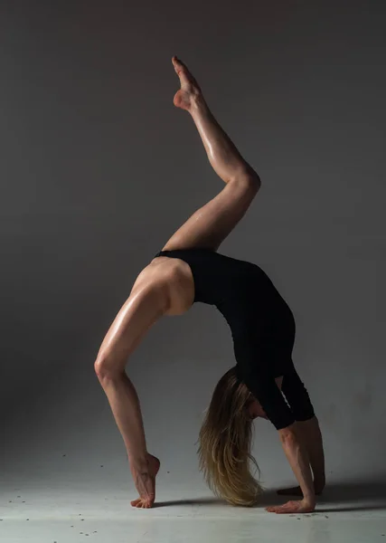性感的女孩做体操来做伸展运动 漂亮性感柔韧的女人展示性感柔韧的身体 弹性延伸到黑色背景上 强壮而灵活的性感女性身体 — 图库照片