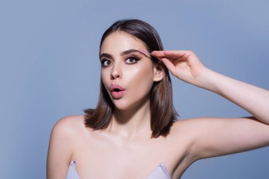 Woman comb eyebrows with eyebrow brush. Care for brows, eyebrows lamination. Brow beauty procedures. Beautiful woman with long eyelashes, eyebrows