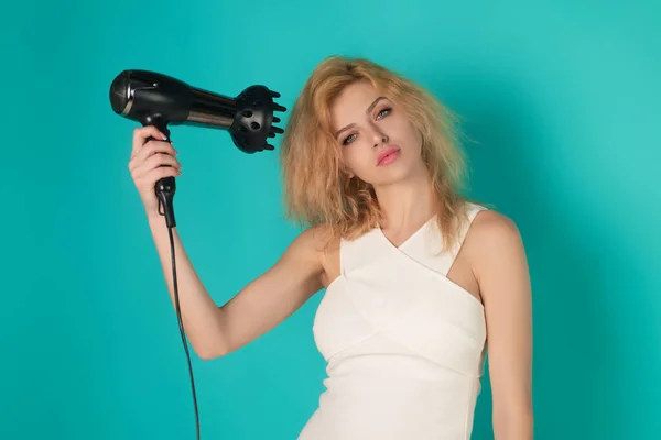 带吹风机的金发女青年 工作室背景 发型和美感概念 漂亮的女孩与吹风机干燥的头发 漂亮女孩用吹风机擦干头发 吹干燥机 — 图库照片