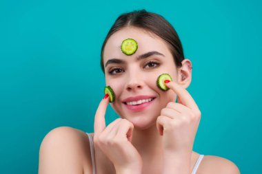 Salatalık maskesi. Kozmetik, kozmetik, dermatoloji. Salatalık maskeli kadın yüzü. Yüzünde salatalık dilimleri olan kadınlar maskeli kadınlar.