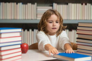 Okula dönelim. Okul kütüphanesinde okuyan bir öğrenci. Kütüphanede kitap okuyan çocuk kitaplığı arkaplanı