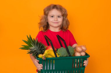 Elinde alışveriş sepeti olan çocuk. Çocuk alışverişte. Alışveriş arabası olan küçük bir çocuk. Süpermarket ve bakkal. Alışveriş, indirim, satış konsepti