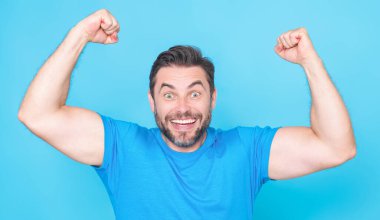 Şaşırmış ifadeli duygusal heyecanlı bir adam. İnsan tepkisi ve duyguları. Yüz ifadesi olan heyecanlı bir adamın stüdyo portresini kapat. Duygusal adam yumruklarını kaldırıyor, başarıyı kutluyor.