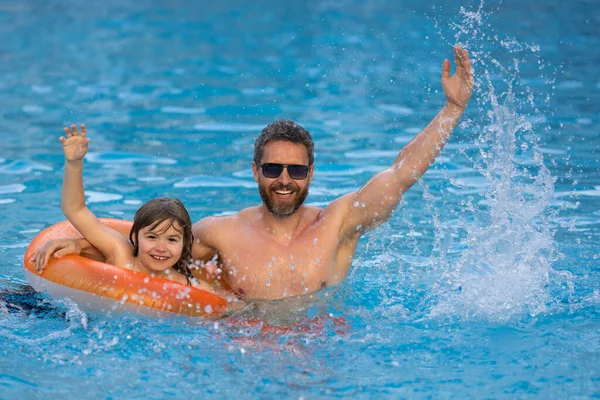 stock image Father and son have fun in swimming pool. Fathers day. Father and son in poolside, summer family. Child with dad playing in swimming pool. Family in pool. Summer vacation. Pool kids party