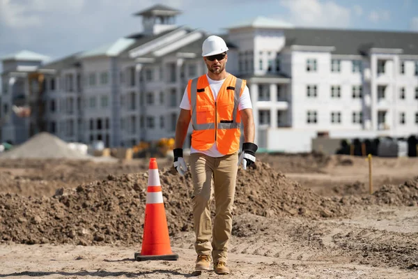 建筑工人戴着安全帽在建筑工地 建筑工地附近穿着建筑工人制服的建筑工人 工地建屋时建筑商的画像 — 图库照片