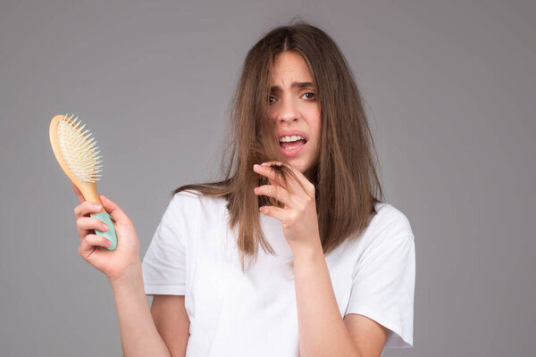 Женщина держит расческу с серьезной проблемой выпадения волос для шампуня здравоохранения