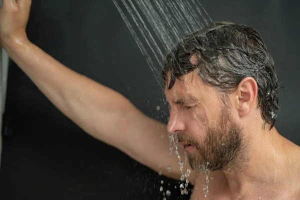 バスルームで髪を洗う男 バスタブの中で男の入浴シャワーヘッド 男性はシャワーを浴びている バスルームでシャワーを浴びてる男 シャワーを浴びてる 浴室の概念 男は浴室の水滴の下にある — ストック写真