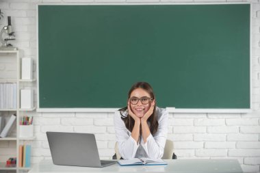 Üniversite ya da lisede çekici bir genç kızın portresi. Serbest çalışan bir kadın mı yoksa dizüstü bilgisayarlı gözlüklü bir öğrenci mi?