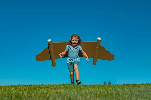 空に翼を持つ男の子は パイロットと飛行の夢を想像しています — ストック写真