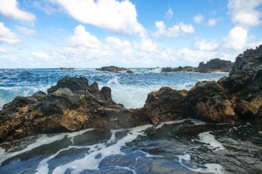 Dalga sahildeki kayaya çarptı, deniz suyu denize sıçradı. Deniz Burnu. Dalgalar kayalık kıyıya çarpıyor.