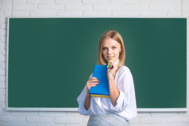 Female student on lesson lecture in classroom at high school or college. Female student taking notes from a book in college