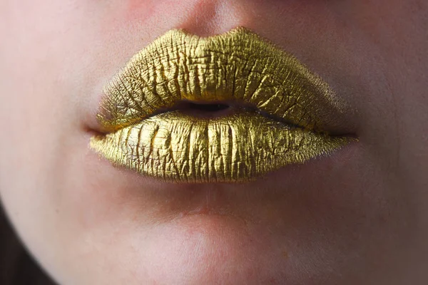 Gold lips, golden lipgloss on sexy lips, metallic mouth. Beauty woman mouth. Sexy girl golden lips, gold mouth. Glowing gold skin and gild lips. Metallic shine golden lip gloss