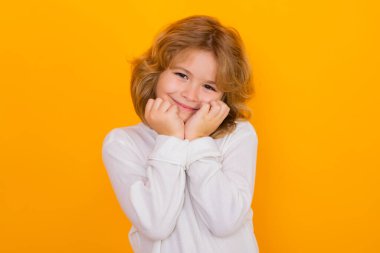 Cute child boy dream on yellow isolated studio background. Child daydreaming and imagination. Kindness kid, mind imagine fantasy